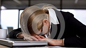 Female employee lying on laptop, annoyed with work, nervous breakdown, stress