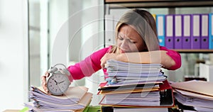 Female employee with many paperwork in office