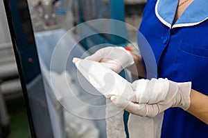 A female employee performs visual quality control of hosiery