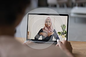 Female employee talk on video call with Muslim colleague