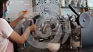 Female employees make hot coffee lattes for customers.