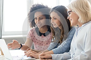 Female employees working together explain ideas on laptop