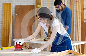 Female engineer architect foreman labor worker wears safety goggles gloves using polishing machine grinding