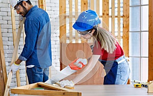 Female engineer architect foreman labor worker wears safety goggles hard helmet jeans apron gloves using