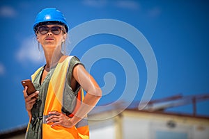 Female engineer architect with a safety helmet and a cell phone