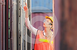 Female engineer checking containers box with from cargo container