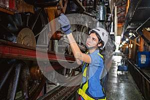 Female engineer checking equipment in factory for repair