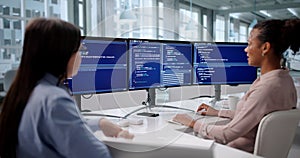 Female Engineer Developing Software On Multiple Computer Screens