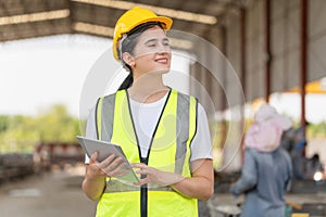 Female engineer with digital tablet at the factory warehouse, Young beautiful woman foreman worker in the construction site