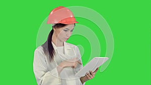 Female engineer in helmet using tablet computer on a Green Screen, Chroma Key