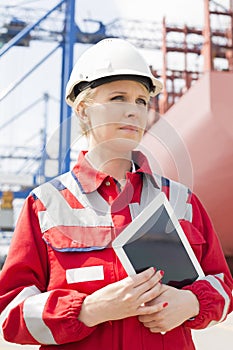 Female engineer holding tablet computer in shipping yard