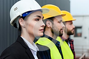 female engineer and male workers in helmets