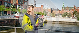 Female engineer with protective equipment stands in the Hamburg port city