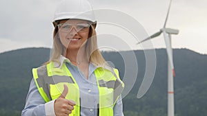 A female engineer shows her thumb as a sign of quality, success and approbation. Work for nature: scientist looks at how