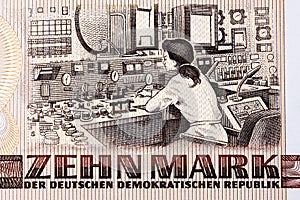 Female engineer sitting at a control console inside the Rheinsberg Nuclear Power Plant from East German money