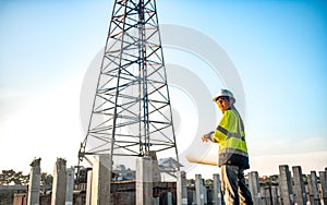 A female engineer is standing and inspecting the progress of the pillar installation