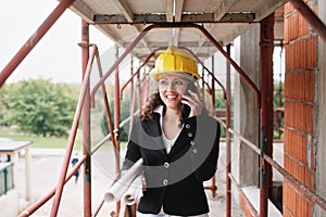 Female Engineer Talking On Mobile Phone In Construction Site