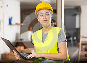 Female engineer using laptop in apartment