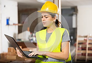 Female engineer using laptop in apartment