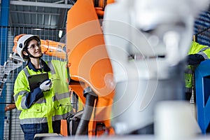 Female engineer using tablet checking system robot arm automate. robotic automation in line production at industrial. Test