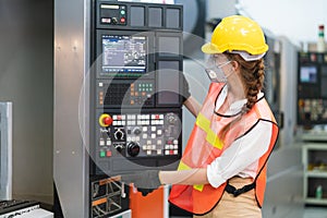Female Engineer wear face mask with safety vest and yellow helmet operating control CNC Machinery at factory