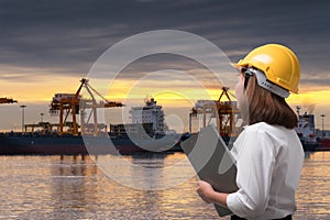 Female engineer wearing safety helmet in shipping port