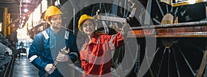 Female engineer and worker checking equipment in factory for repair