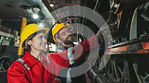 Female engineer and worker checking equipment in factory for repair