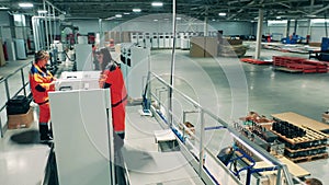 Female engineers are assembling fridges in the factory. Industrial factory assembly line.