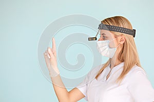 Female ENT doctor, wearing in mask at the hospital looking at the camera