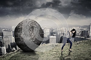 Female entrepreneur with big stone on the hill