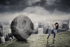 Female entrepreneur with big stone on the hill photo