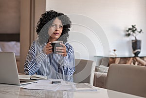 Female entrepreneur drinking coffee while working from home