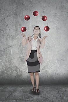 Female entrepreneur juggling red balls