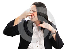 Female entrepreneur making smelly gesture touching nose