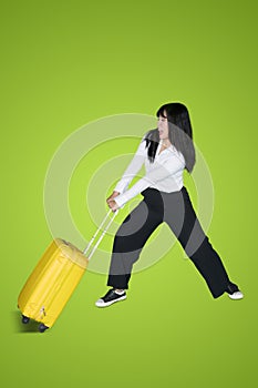 Female entrepreneur pulls a heavy luggage