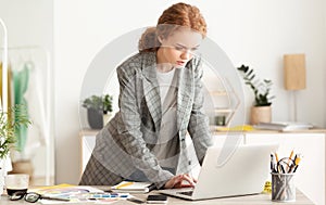 Female entrepreneur responding business emails on laptop