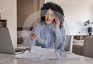 Female entrepreneur talking on her cellphone while working at home