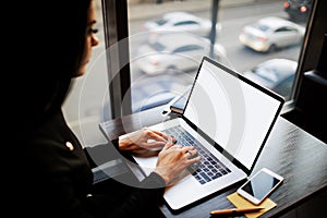 Female entrepreneur using pc laptop computer with blank monitor background with copy space for promotional content