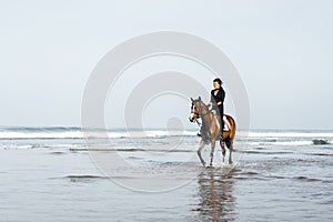 female equestrian riding horse in wavy