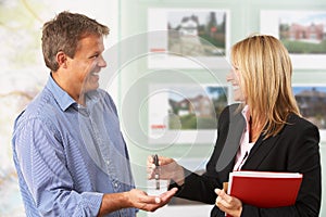 Female Estate Handing Over Keys Of New Home photo