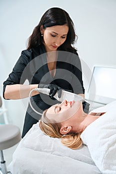 Female esthetician performs a hardware rejuvenation procedure