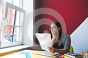 Female executive director reading resume during work day in company