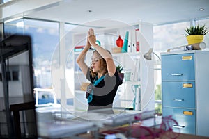 Female executive doing yoga in office