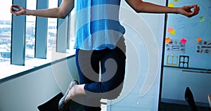 Female executive performing yoga at her desk