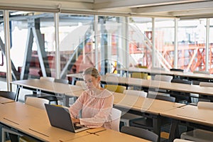 Female executive using laptop in the conference room at office