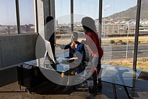 Female executives working on desktop pc at desk in office