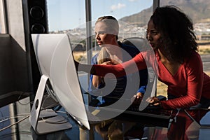 Female executives working on desktop pc at desk in office