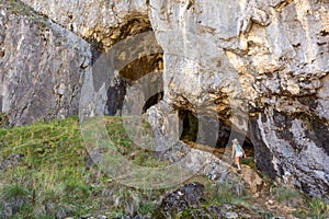 Female explorer entering a cave system