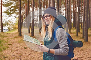 Female explorer with map outdoor in the forest in autumn